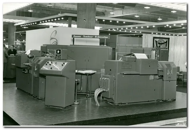 The operator console is visible in the foreground, along with two tabulating machines. The CPU and memory cabinets are in the background.